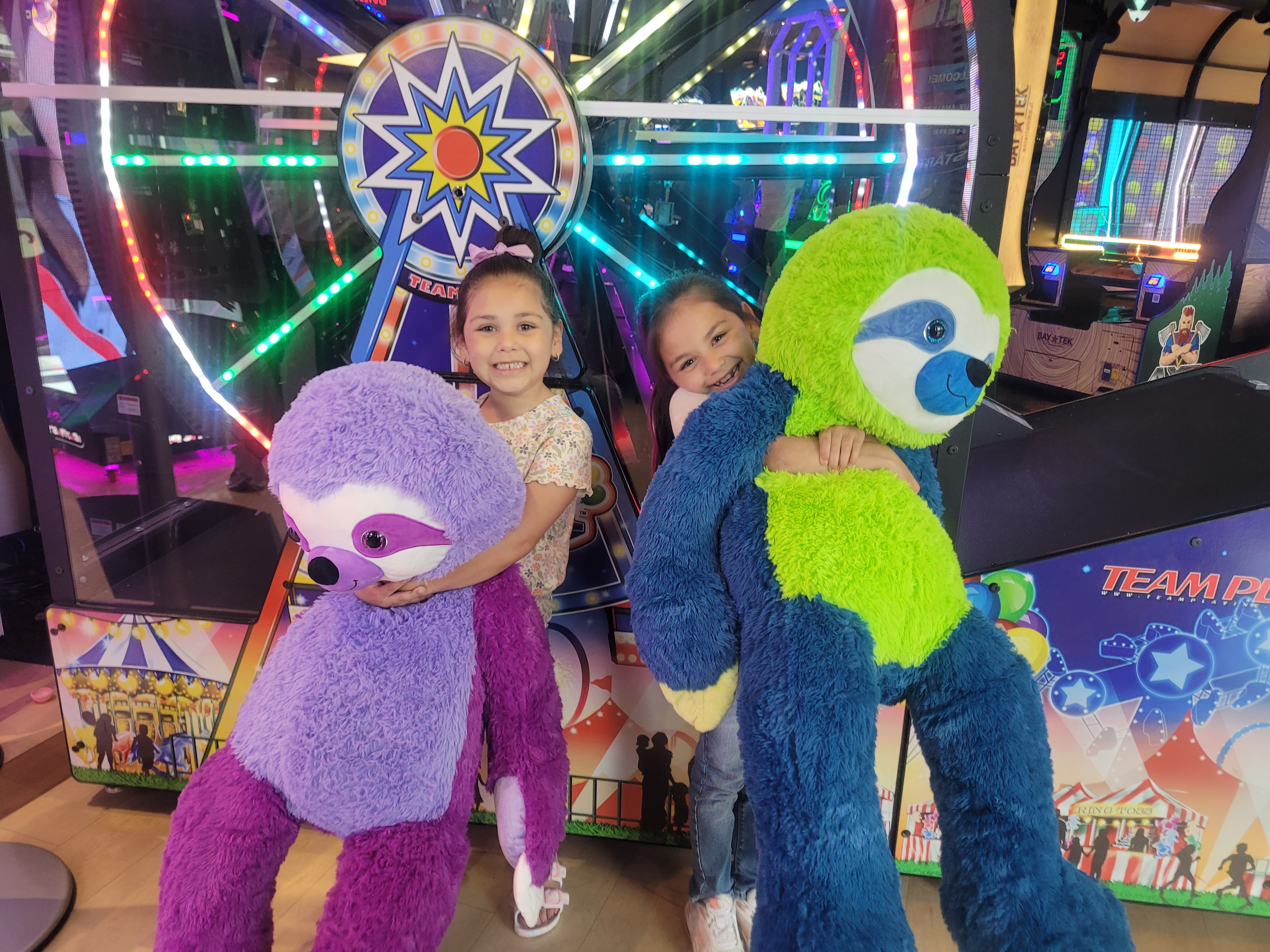 two girls holding big stuffed animals
